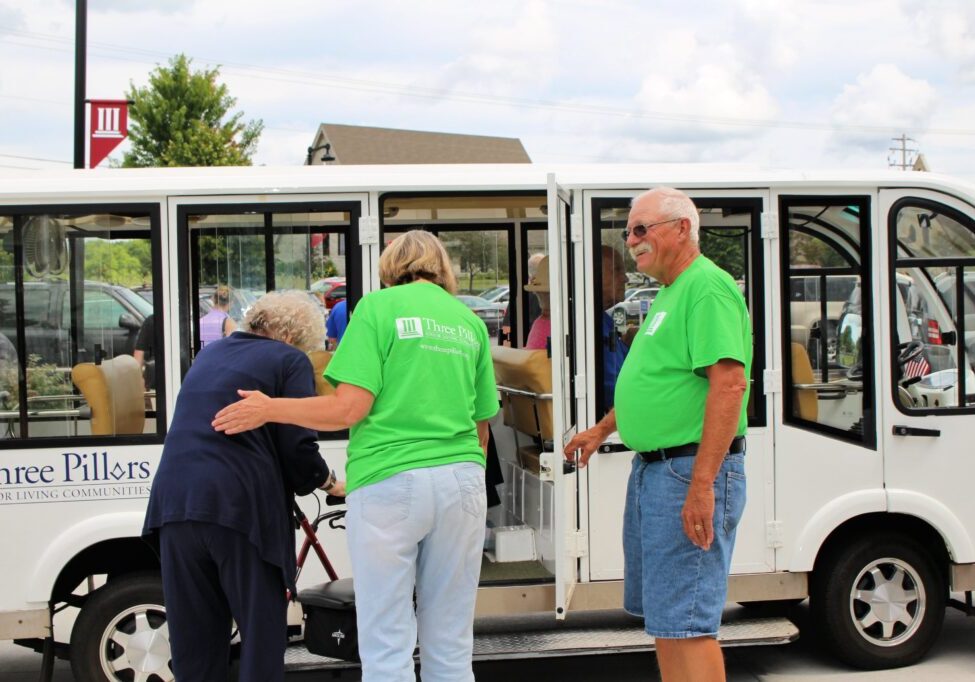 Volunteers at a Life Plan community help guests on the shuttle
