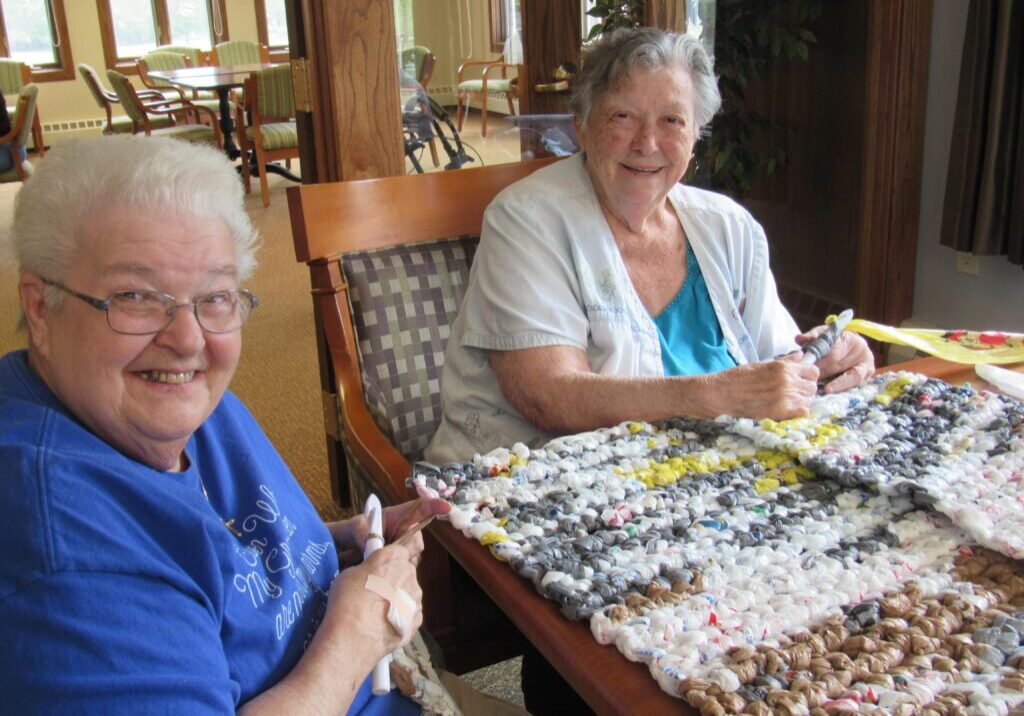 two senior living residents working on craft project for charity