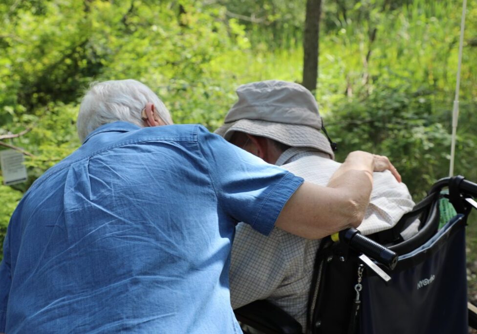 elderly couple with arms around one another