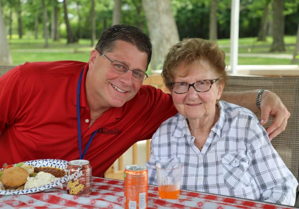 Nurse with elderly woman enjoyng lunch outdoors