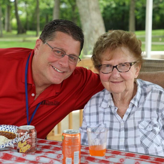 Nurse with elderly woman enjoyng lunch outdoors