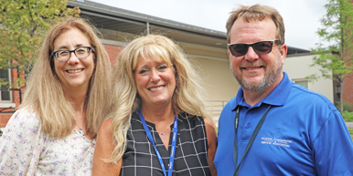 Smiling staff stand together at Three Pillars Senior Living Communities