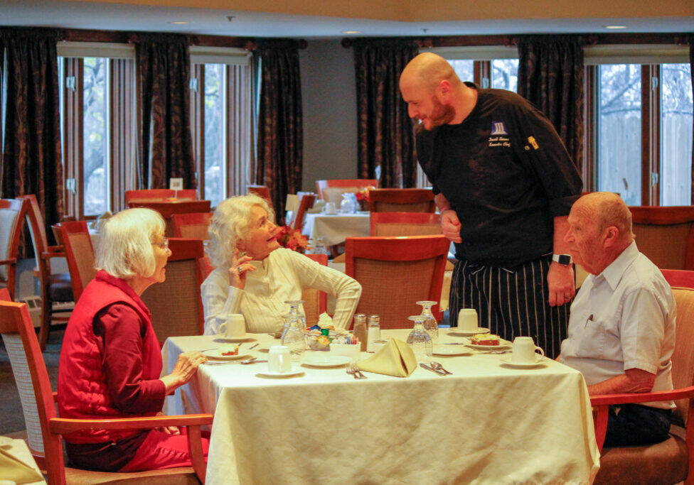 Seniors being served food in assisted living