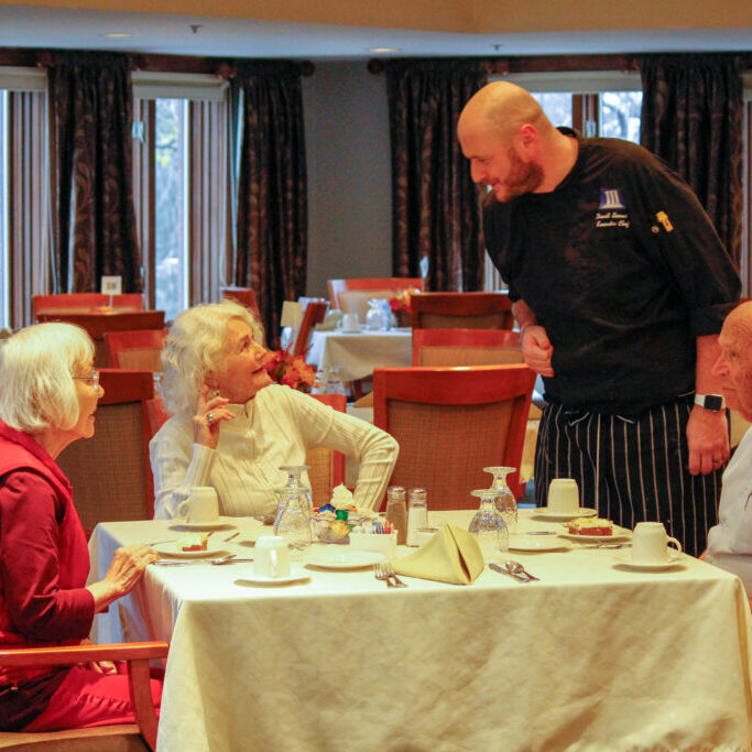 Seniors being served food in assisted living