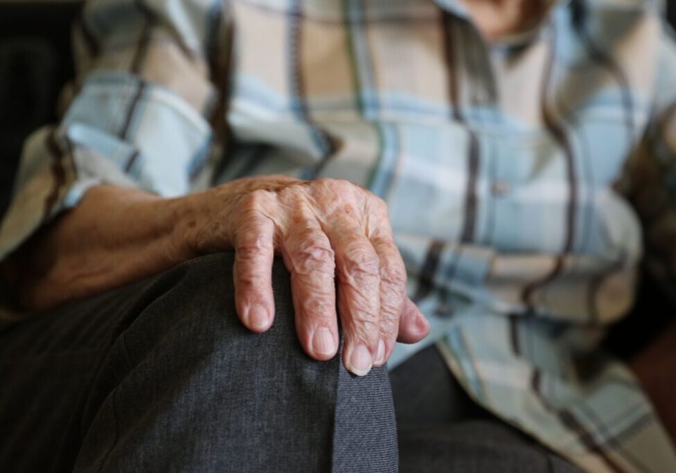 closeup with old woman's hand on her knee