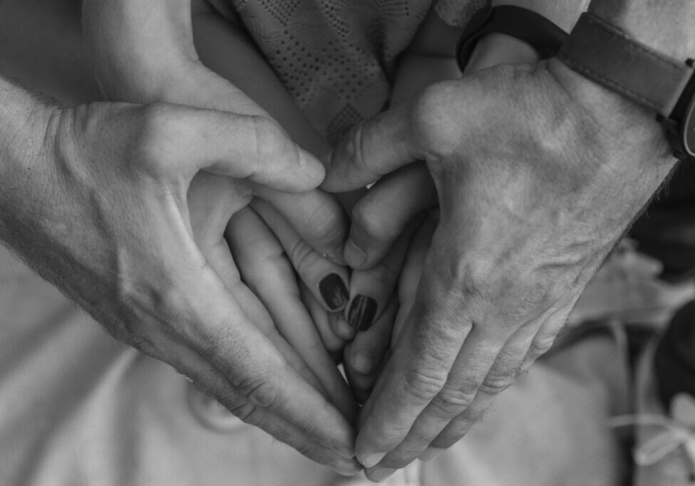 Hands on top of one another making the shape of a heart