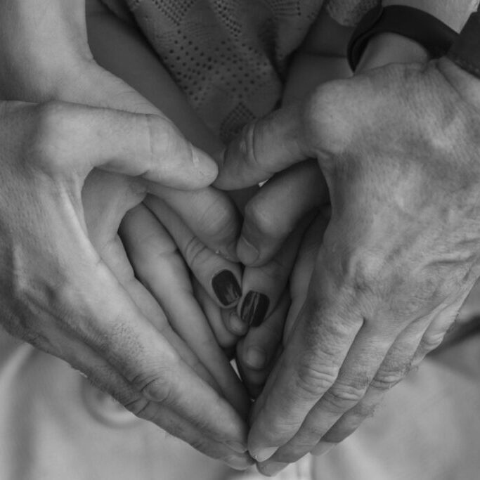 Hands on top of one another making the shape of a heart